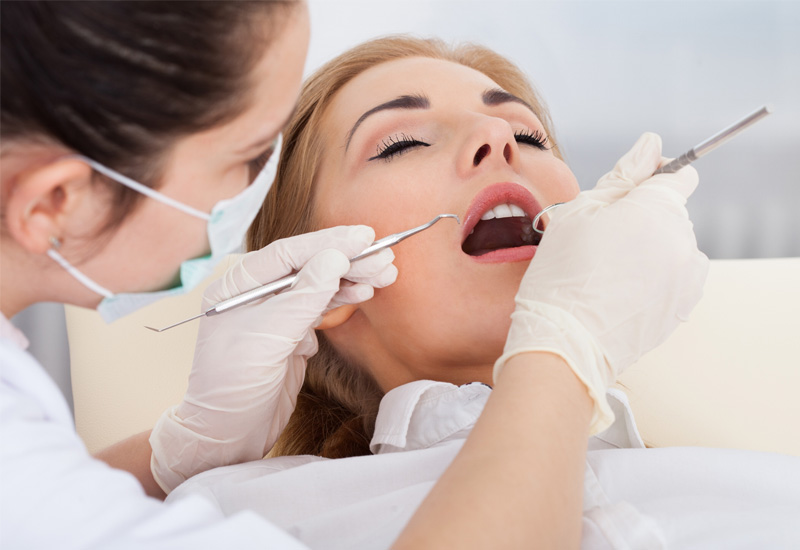 Hình ảnh bác sĩ đang tiến hành thăm khám và nhổ răng khôn cho bệnh nhân